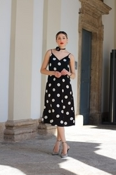 a lady in a black slip dress with white polka dots